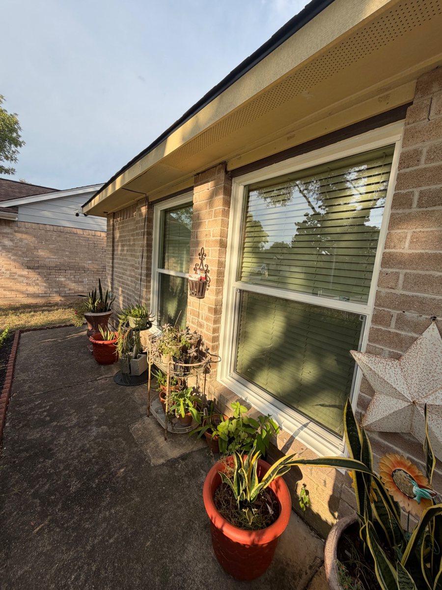 White-frame windows installed on a brick home