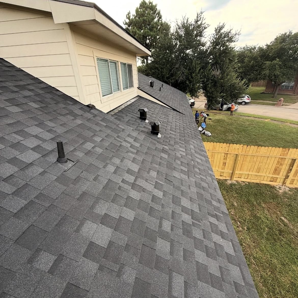 Close view of completed charcoal roof shingles and roof vents