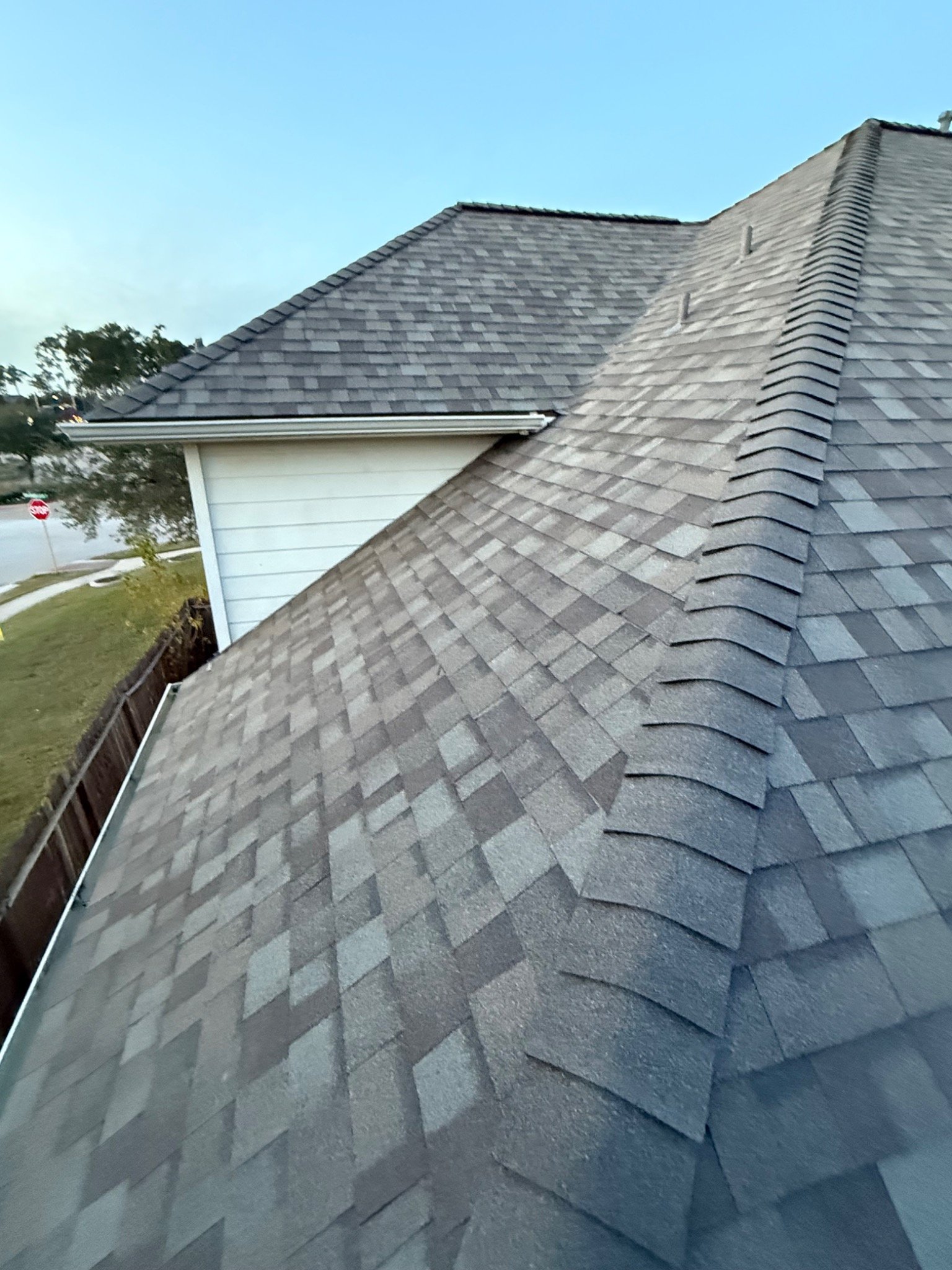 Close-up of finished gray roof shingles and ridge caps